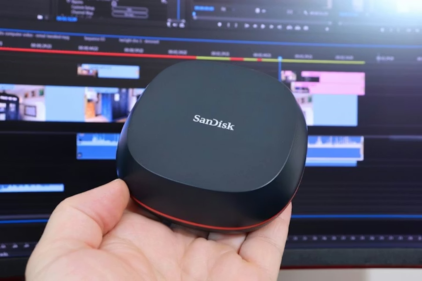 SanDisk Desk Drive portable SSD in front of video timeline monitor