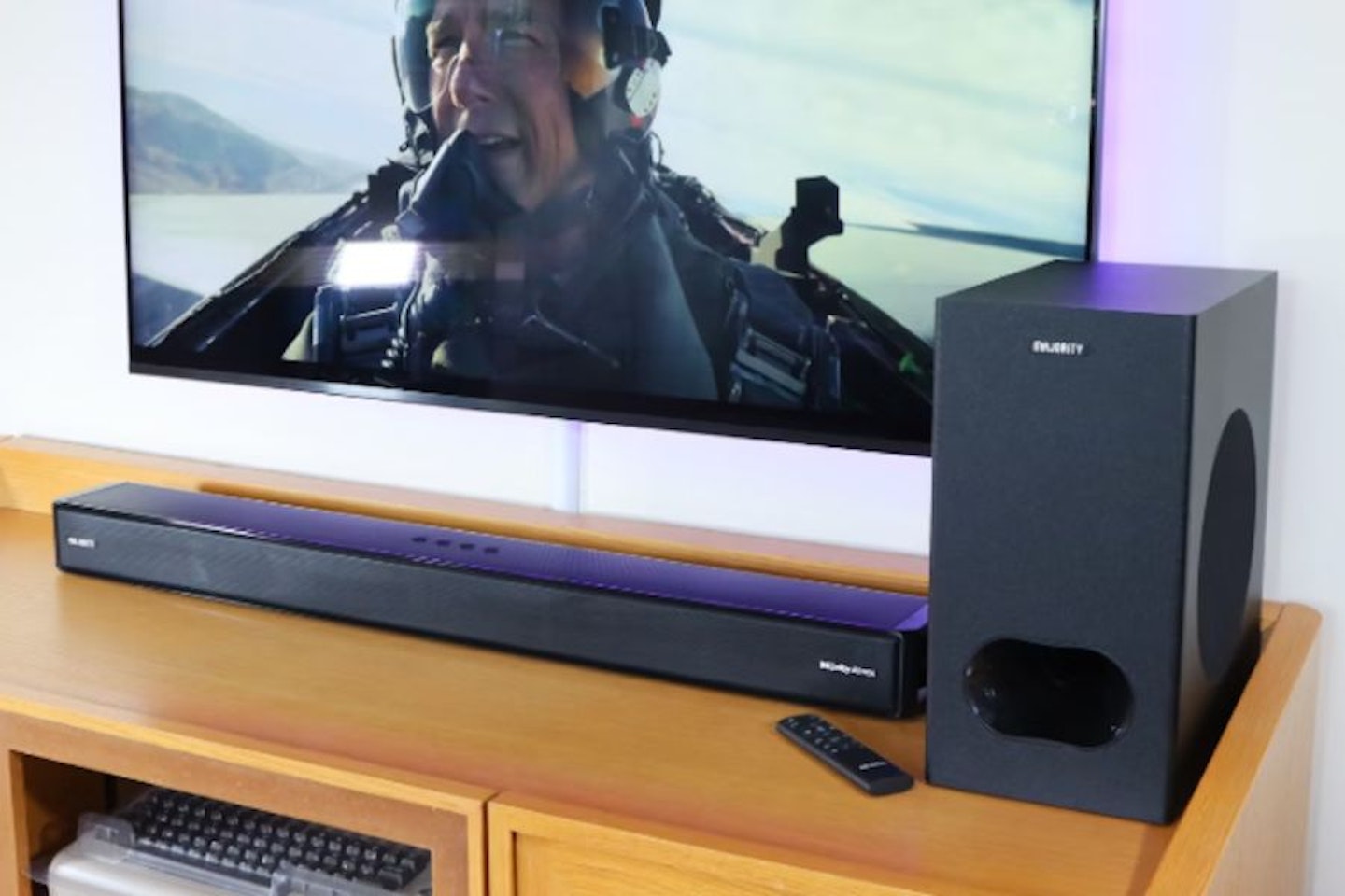 Majority Sierra Plus Dolby Atmos 2.1.2 Soundbar and subwoofer with a TV showing Top Gun Maverick. Best budget soundbars, the best soundbar under £200.