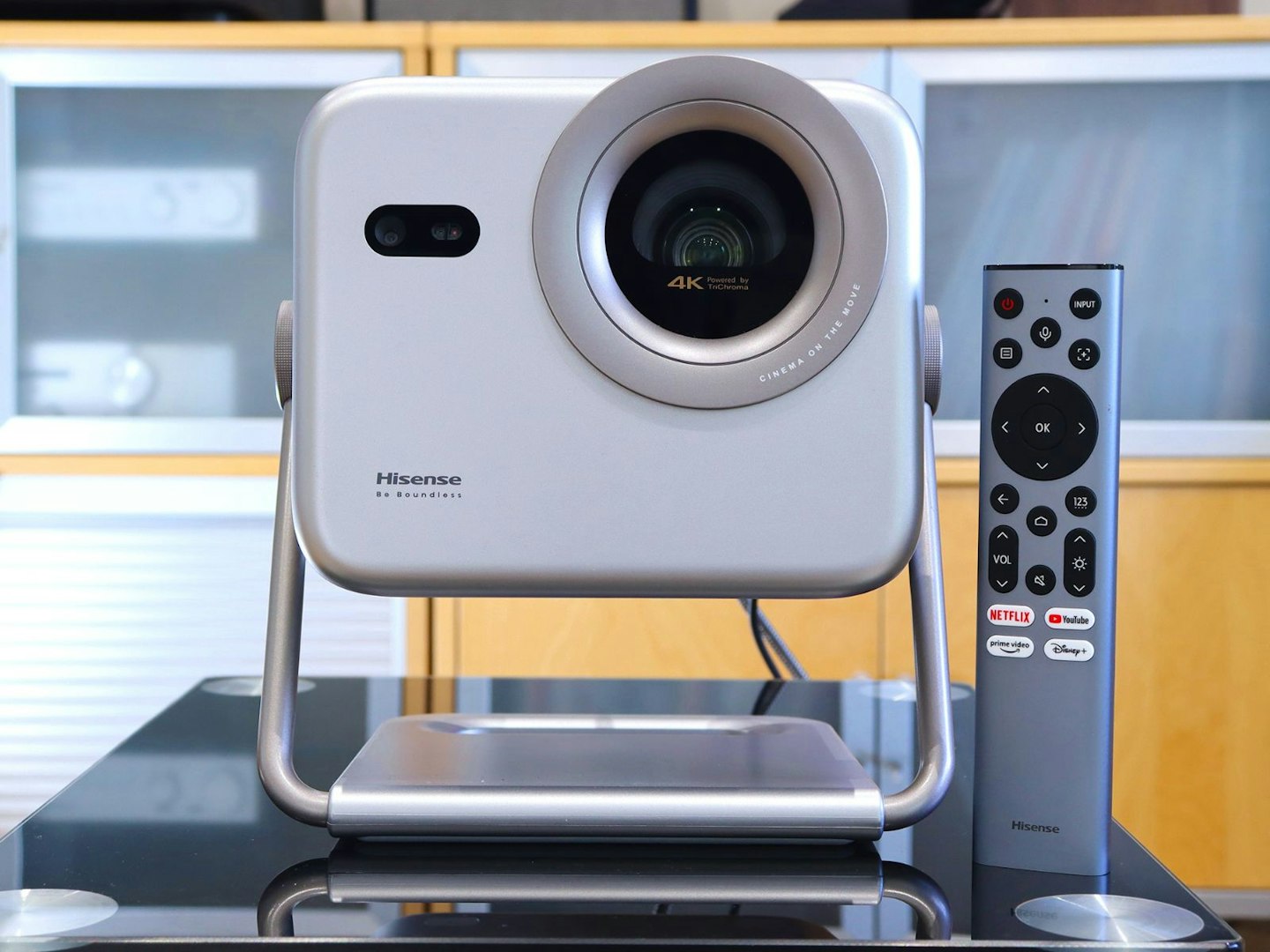 Hisense M2 Pro projector and remote on a table in a lounge